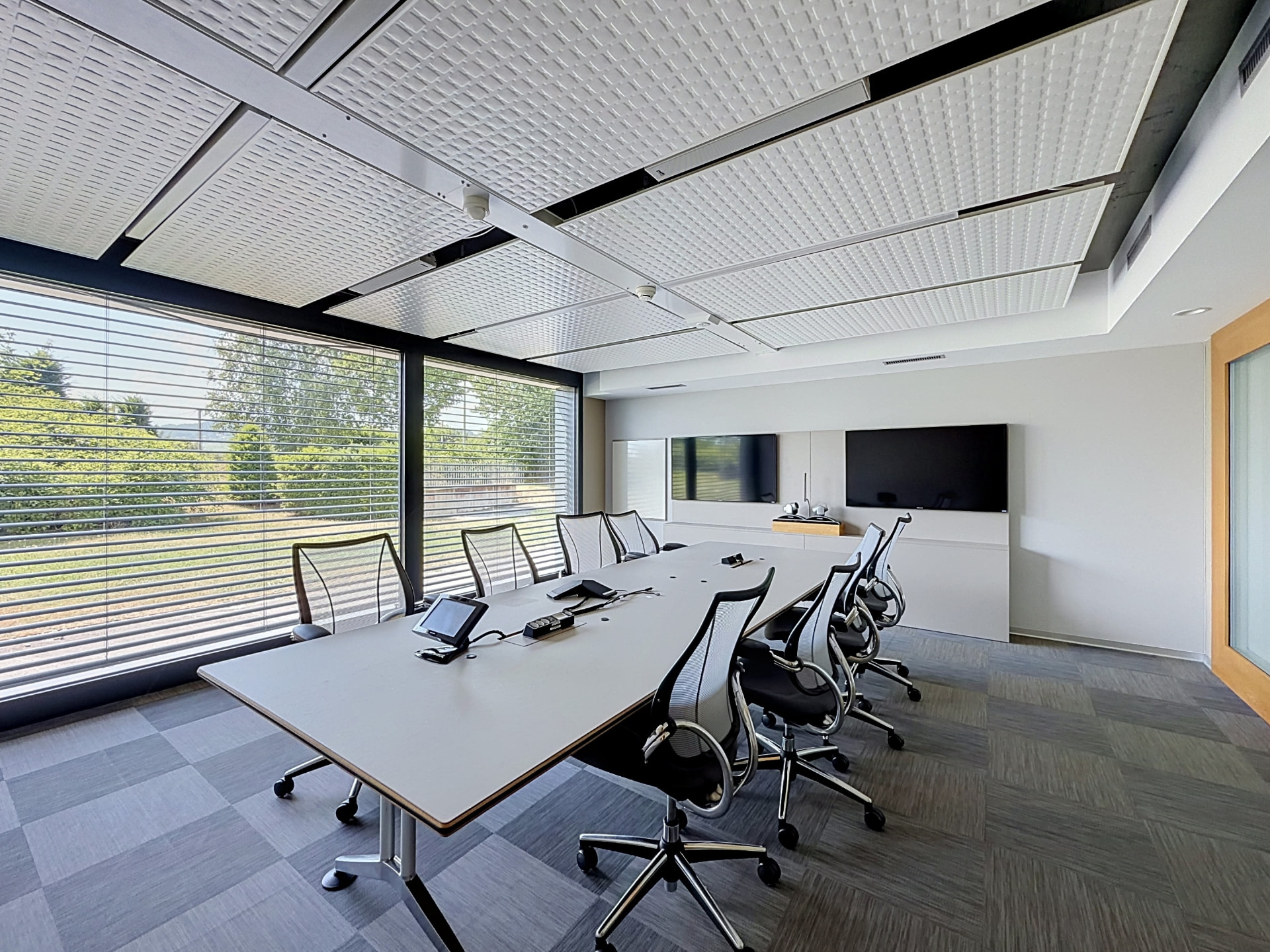 Salle de réunion avec longue table blanche